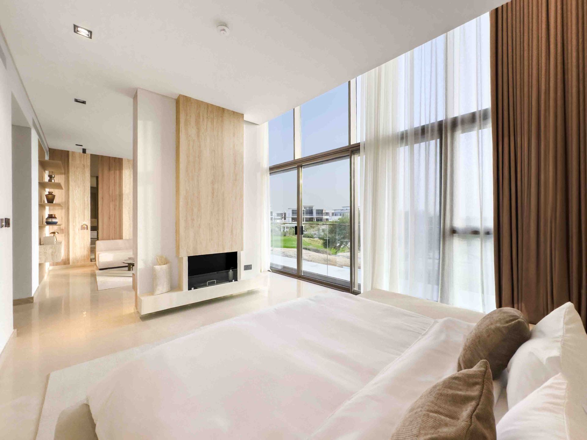 Bedroom suite with travertine fireplace and floor-to-ceiling golf course views