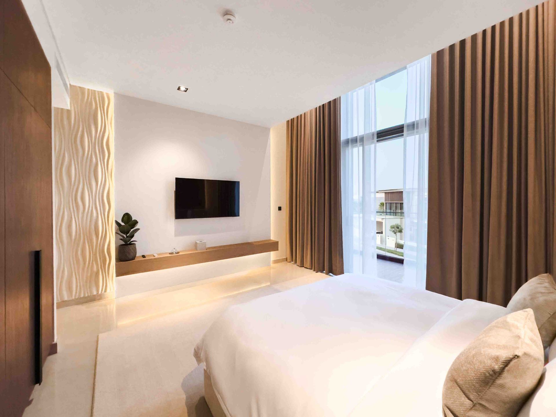 Bedroom with sculpted 3D feature panel, floating oak TV console and cove lighting