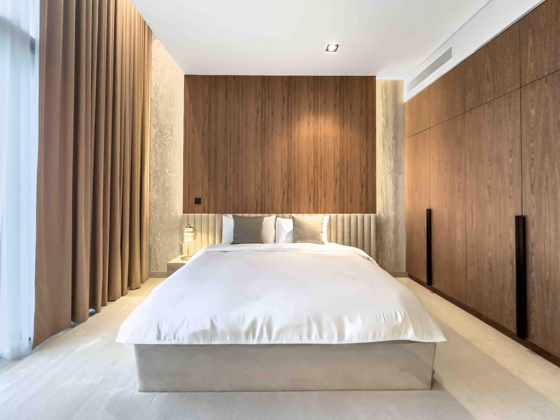 Bedroom with full-height oak headboard wall and fluted upholstered base