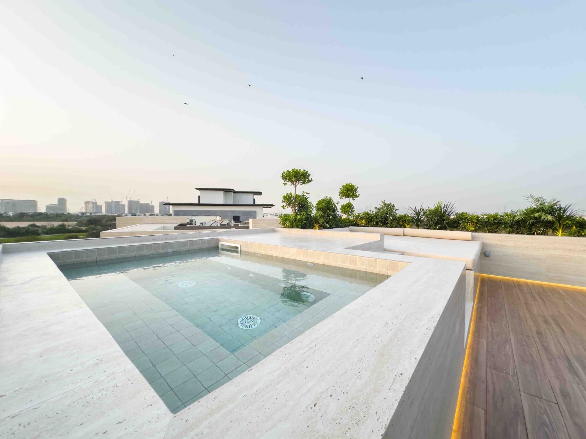 Rooftop terrace plunge pool with travertine decking and skyline views