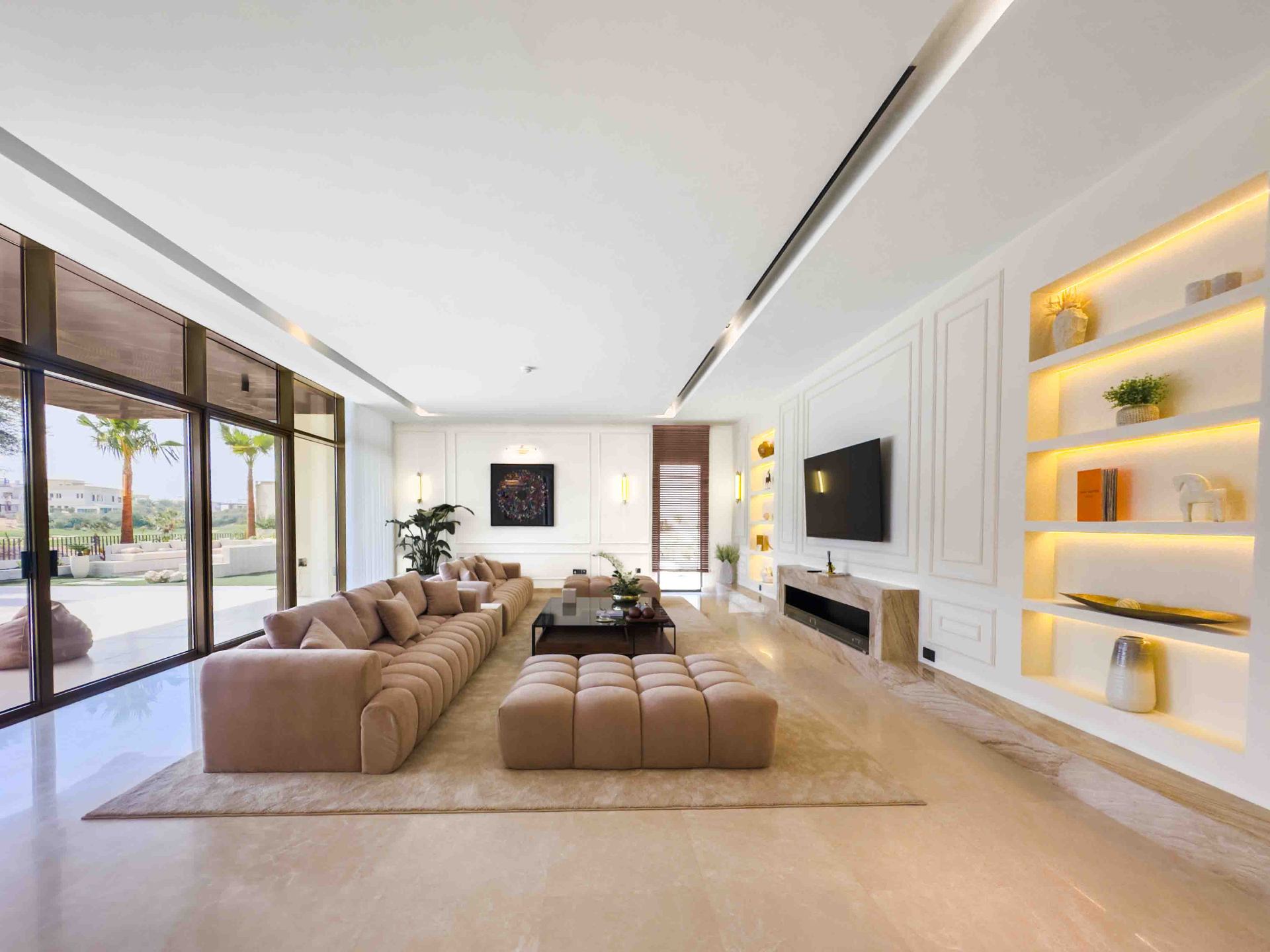 Main living room with modular sofa, travertine fireplace and backlit display shelving