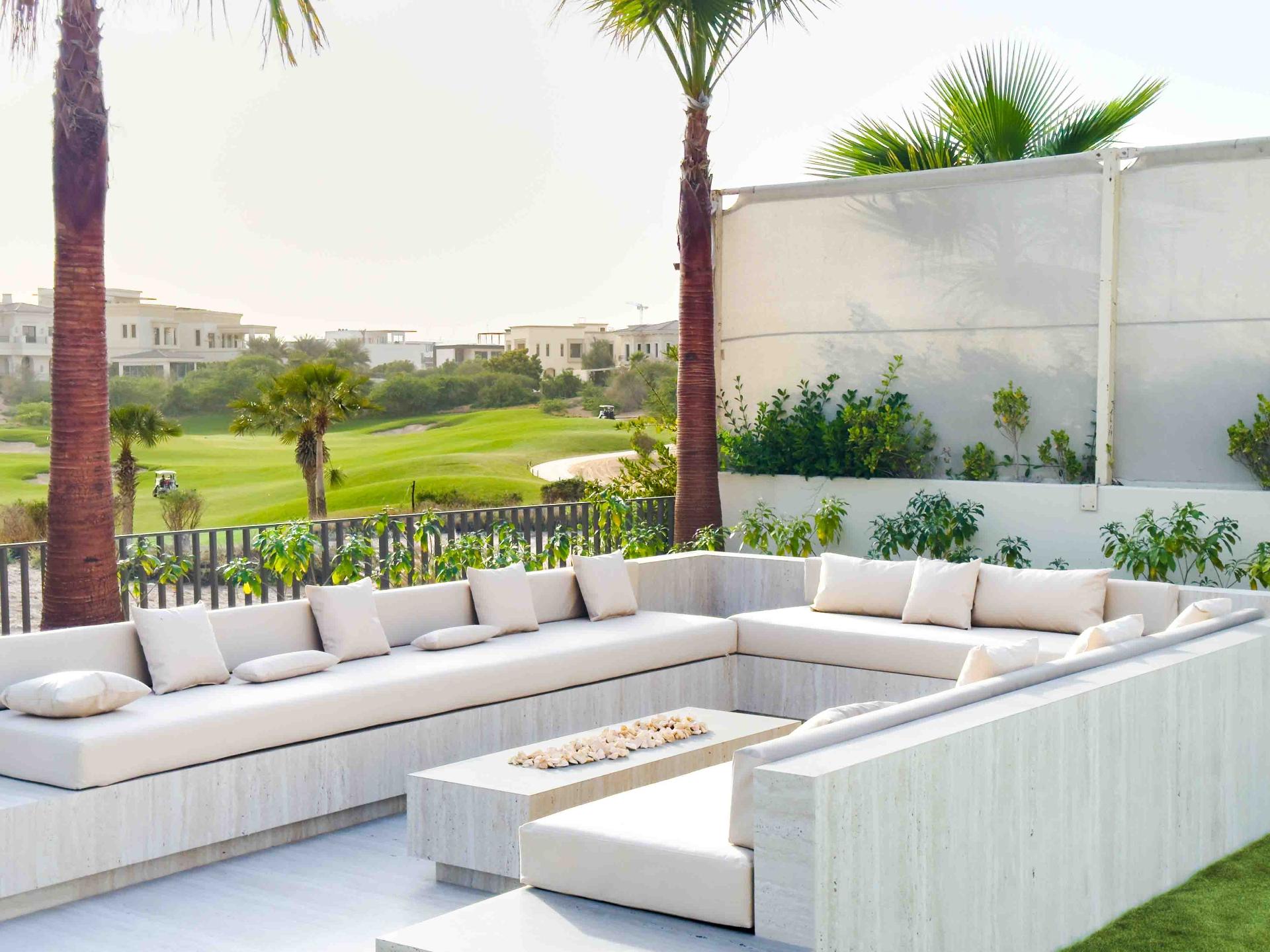 Outdoor travertine lounge overlooking the Dubai Hills golf course