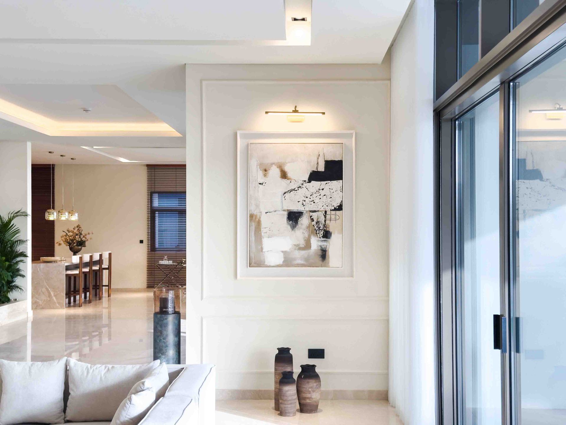 Hallway gallery wall with framed artwork and picture light