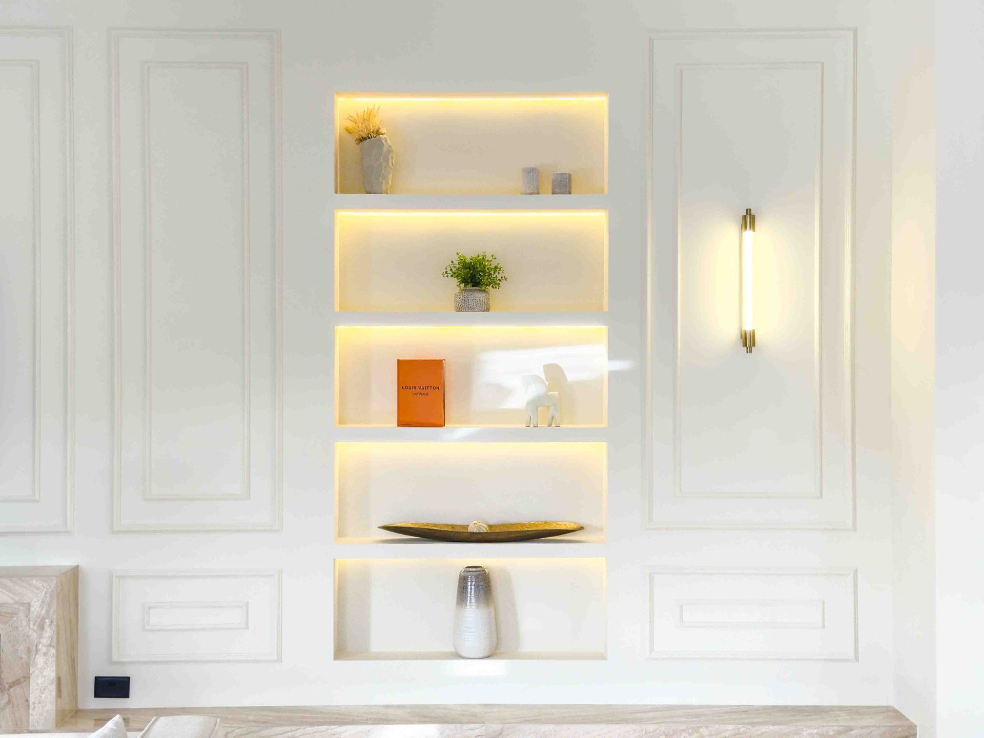 Bespoke joinery niches with integrated warm lighting and panel mouldings