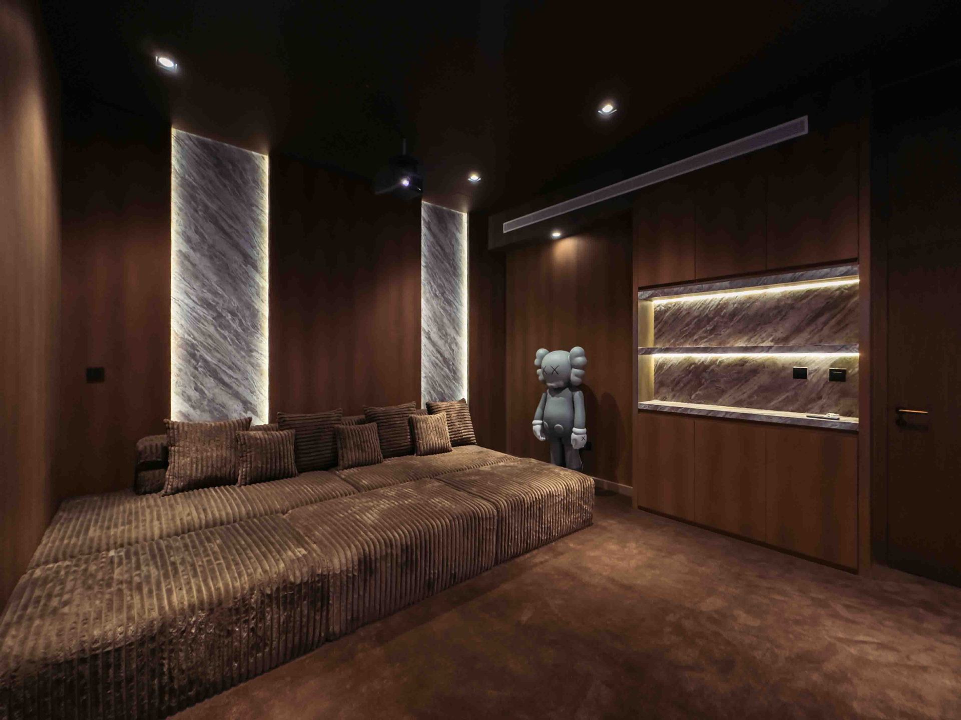 Private home cinema with stone-clad feature walls and corduroy seating