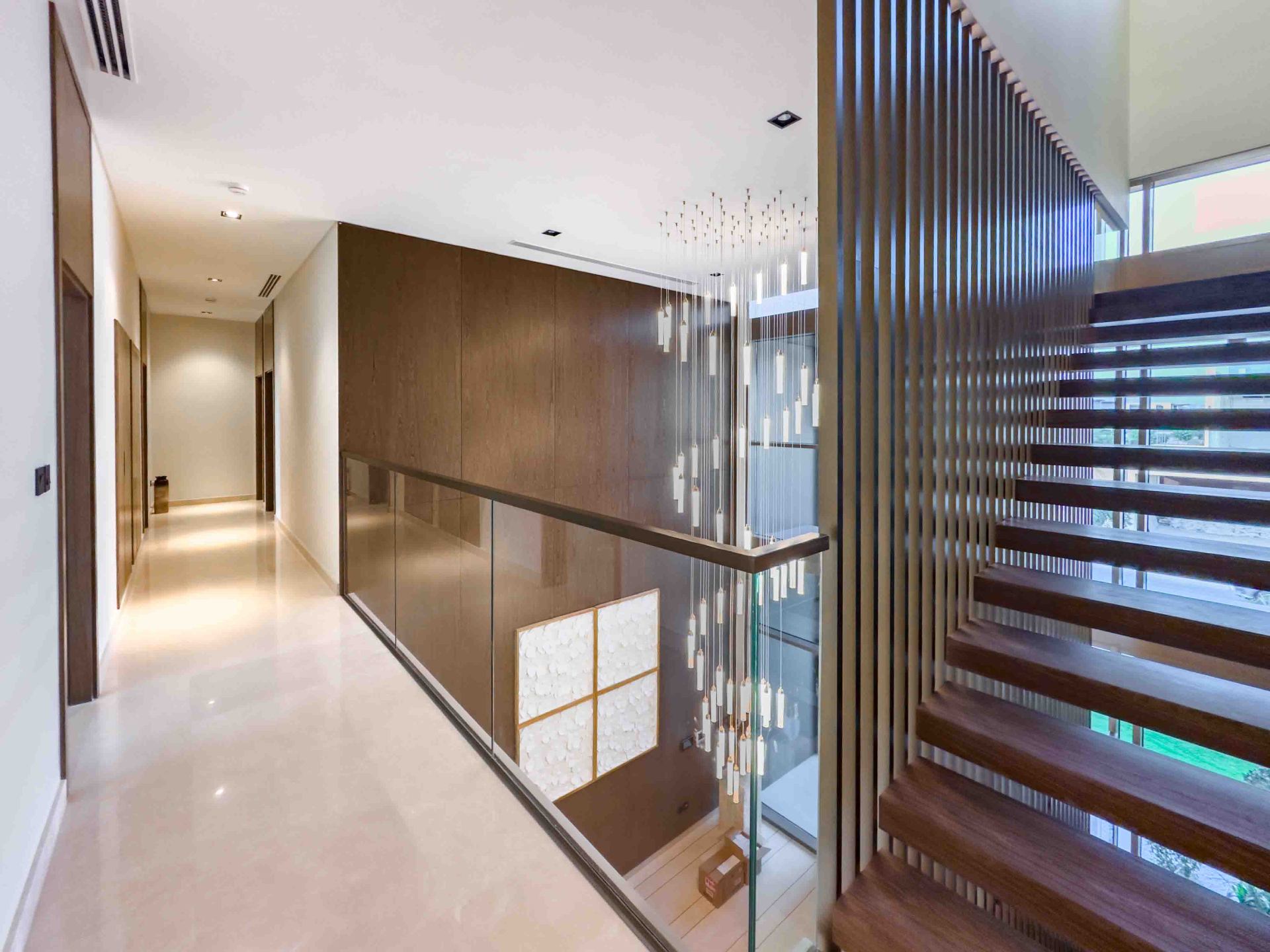 First-floor landing with timber slat staircase and pendant lighting