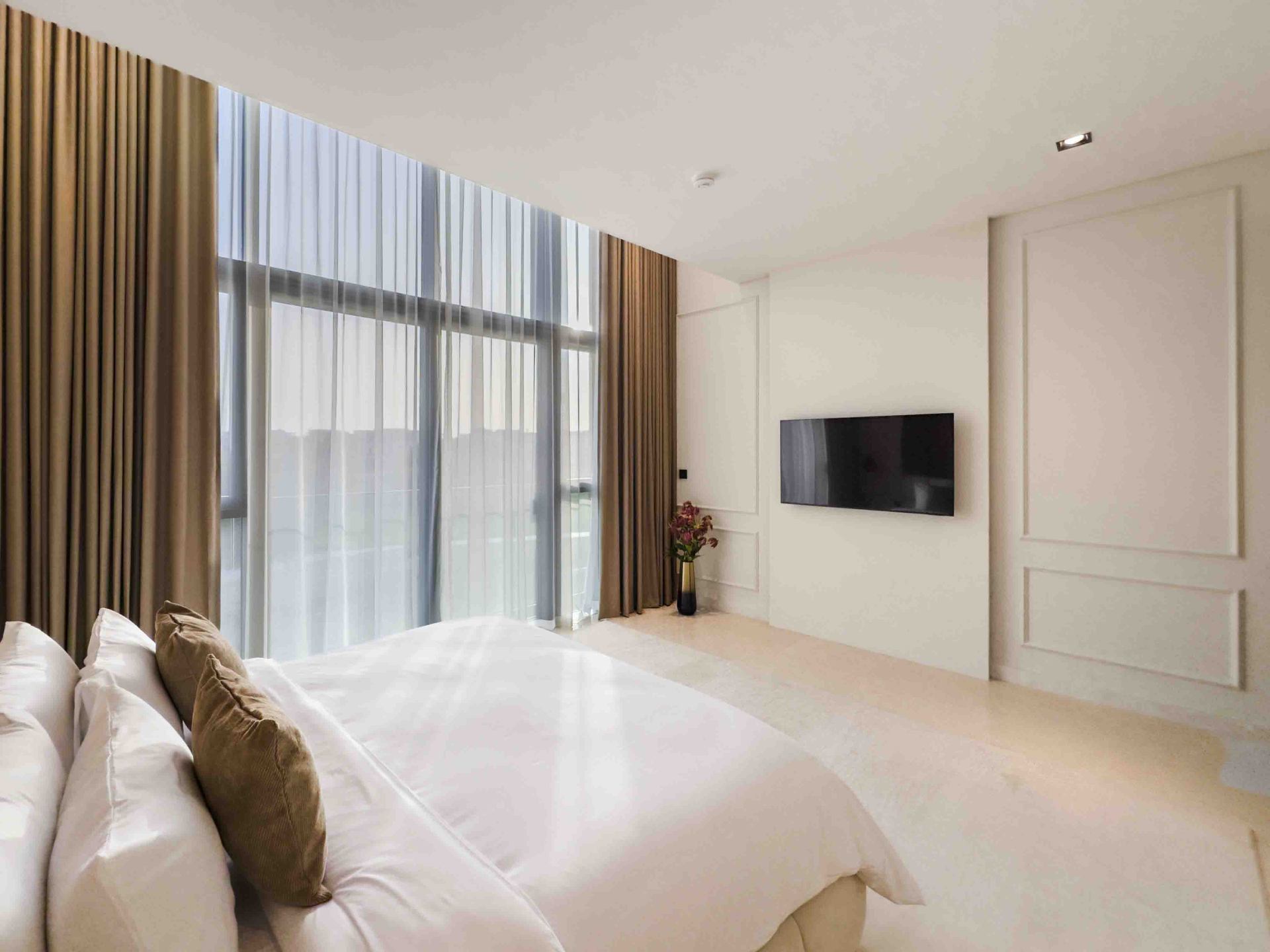 Guest bedroom with panelled feature wall and floor-to-ceiling drapery