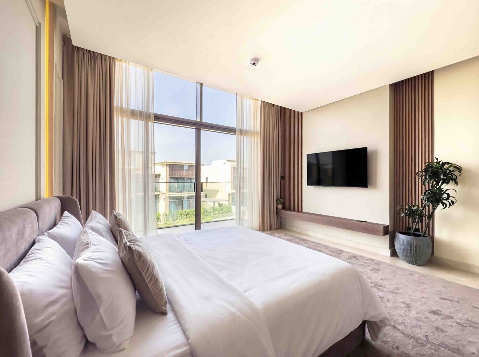 Bedroom with floating timber TV console, fluted oak panels and golf course view