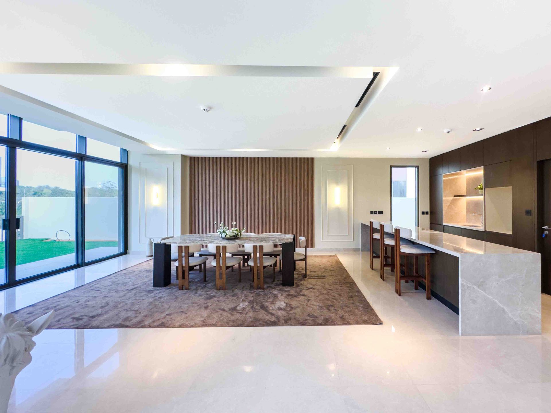 Dining and kitchen view with marble breakfast bar and backlit stone splashback