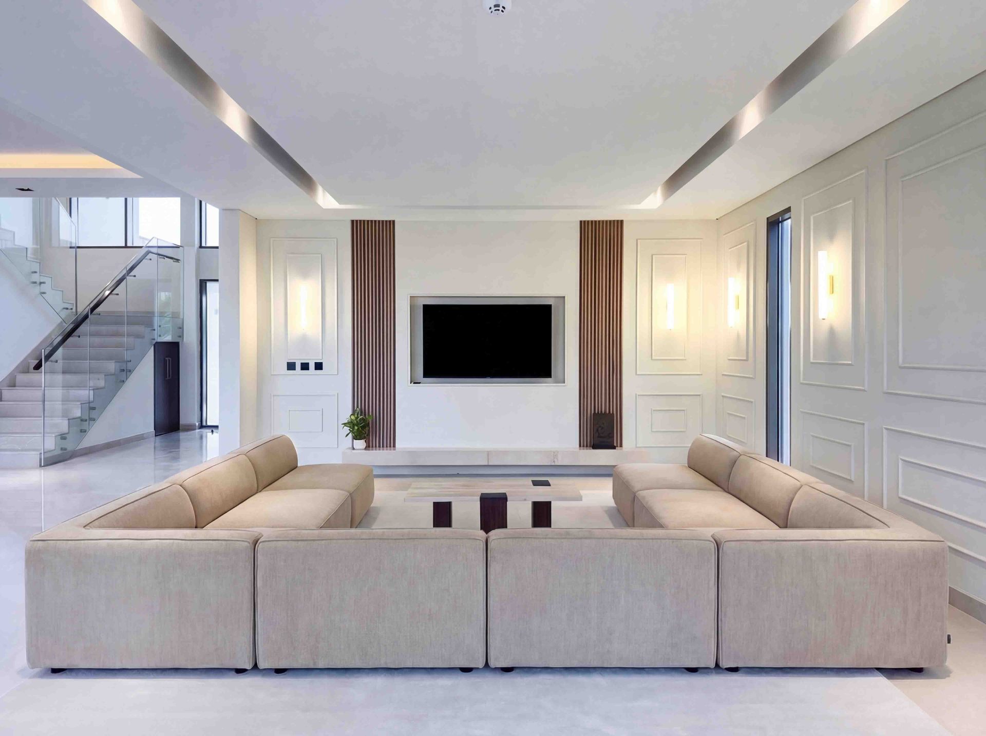 Living room with modular bouclé sectional, travertine console and double-height ceiling