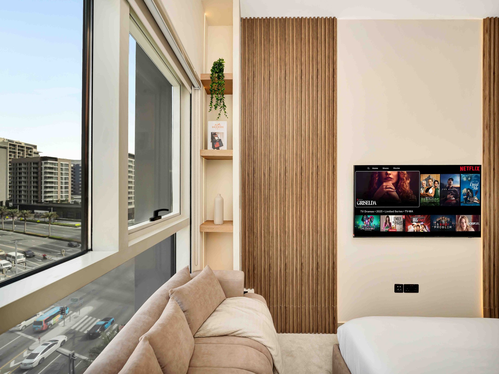 Bedroom corner with fluted oak feature wall, recessed shelving niche and wall-mounted TV